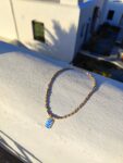 Necklace with gold/white glass beads and stainless steel centerpiece